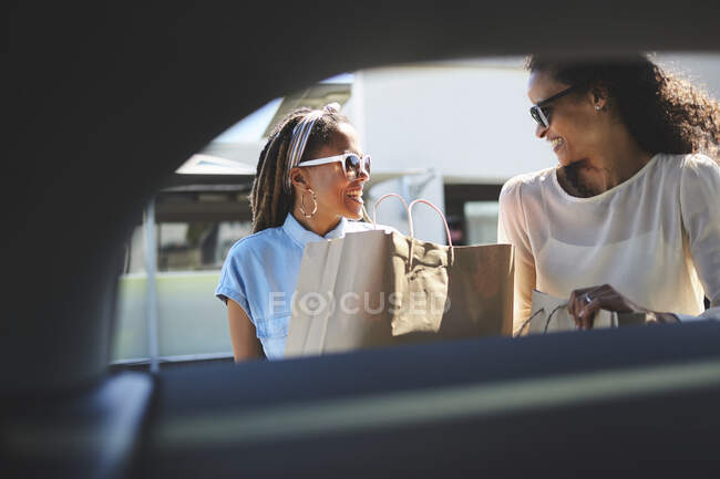 Женщины грузят сумки в машину — стоковое фото