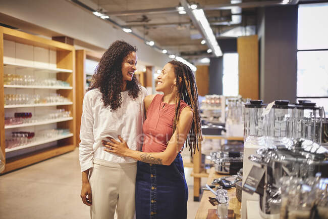Happy lesbian couple shopping in home decor shop — Stock Photo