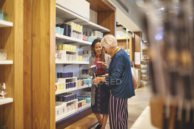 Worker helping senior woman shopping in home goods store — Stock Photo