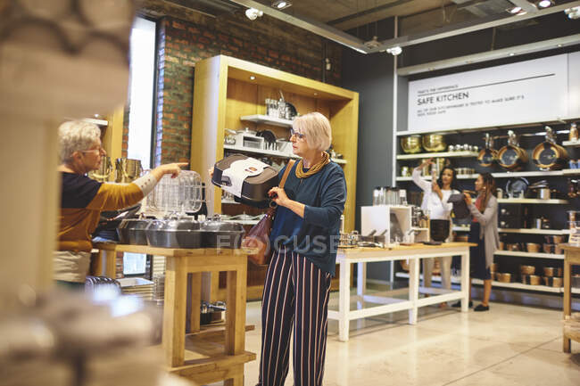 Las mujeres mayores de compras de bakeware en la tienda de artículos para el hogar - foto de stock