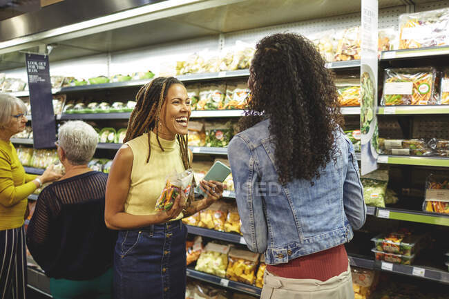 Happy women friends grocery shopping in supermarket produce section — Stock Photo