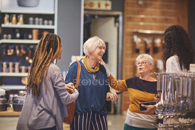 Щасливі жінки говорять про покупки в магазині товарів для дому — стокове фото