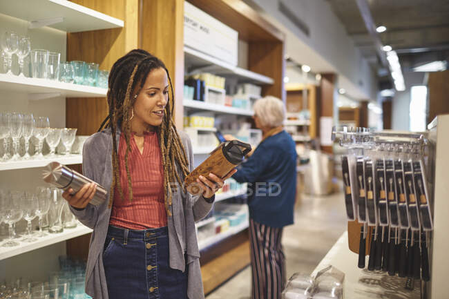 Femme faisant des emplettes pour le récipient de boisson isolé dans le magasin de marchandises à la maison — Photo de stock