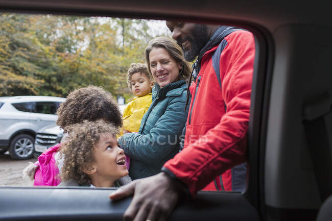 Feliz familia multiétnica fuera de coche - foto de stock