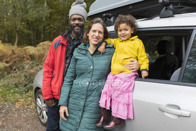 Portrait happy parents and toddler daughter outside car — Stock Photo