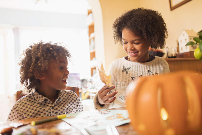 Brother and sister making autumn crafts at table — Stock Photo