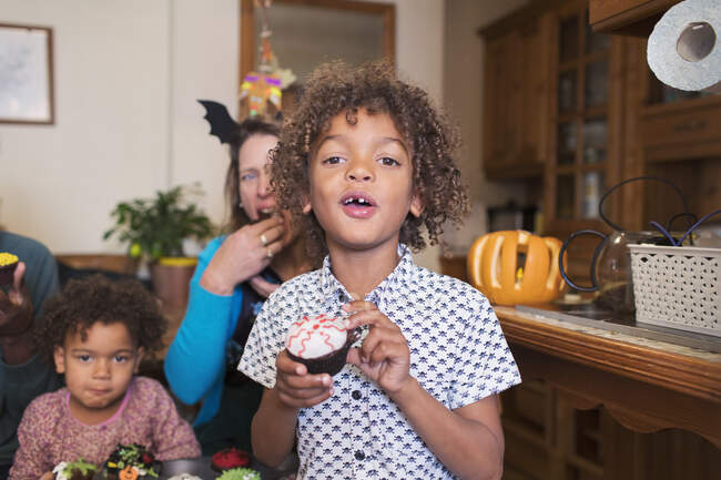 Portrait boy eating Halloween cupcake — Stock Photo
