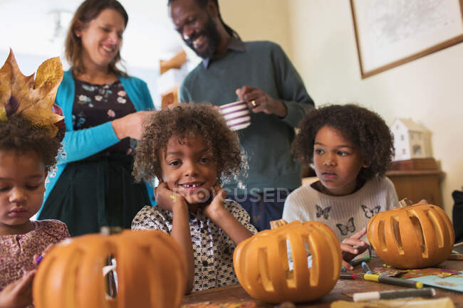 Portrait happy boy carving pumpkins with family — Stock Photo