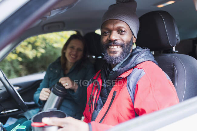 Портрет улыбающейся пары, пьющей кофе в машине — стоковое фото