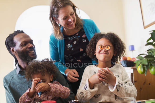 Playful family decorating cupcakes — Stock Photo