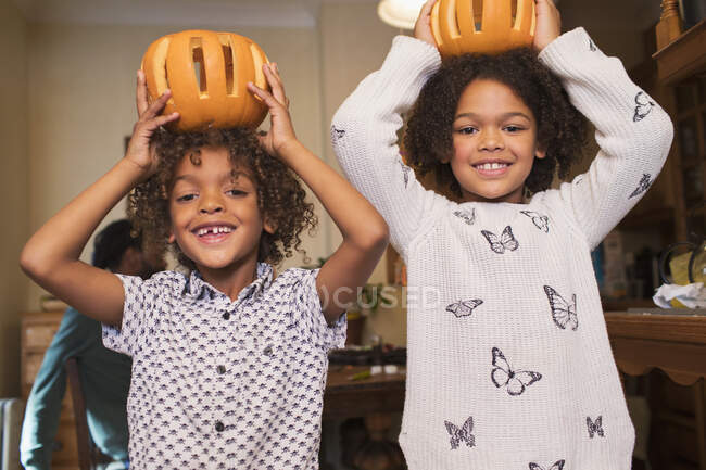 Ritratto di fratello e sorella felice con sopra zucche intagliate — Foto stock