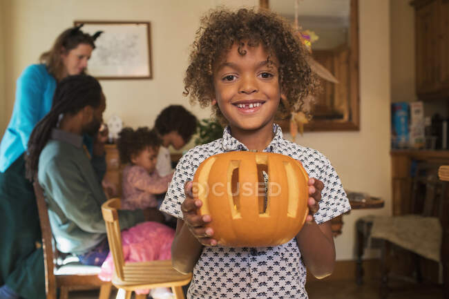 Portrait happy proud boy holding carved pumpkin — Stock Photo