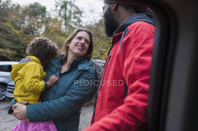 Familia multiétnica hablando en el estacionamiento - foto de stock