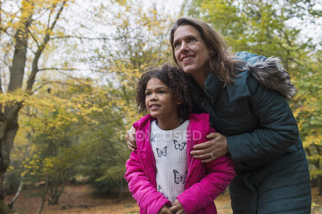 Curiosos madre e hija en los bosques de otoño - foto de stock