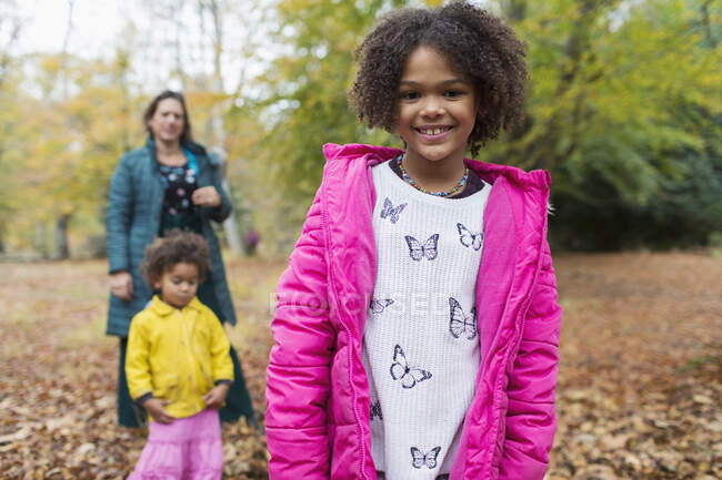 Portrait happy girl with family in autumn woods — Stock Photo