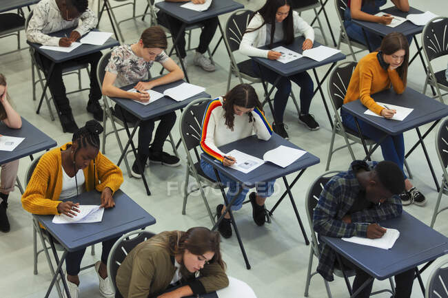Estudantes do ensino médio focados fazendo exame em mesas em sala de aula — Fotografia de Stock