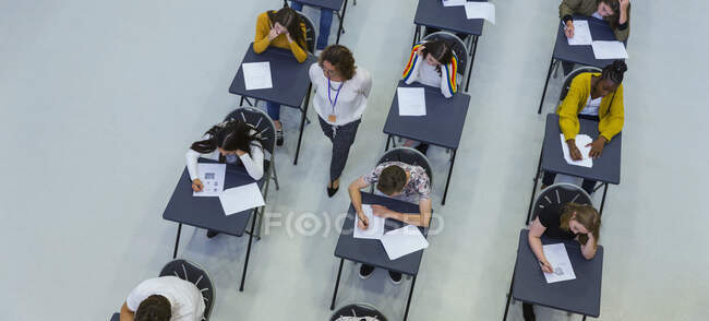 Взгляд сверху: учитель средней школы наблюдает за студентами, сдающими экзамен — стоковое фото