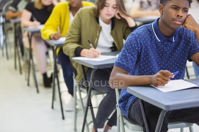 Estudiantes de secundaria enfocados tomando examen - foto de stock