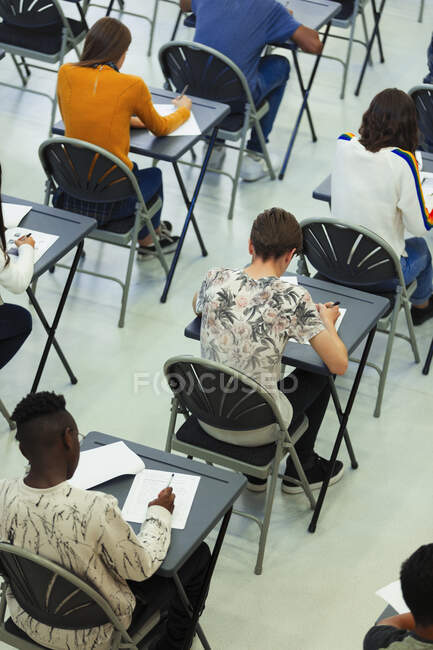 Studenti delle scuole superiori che sostengono l'esame alle scrivanie in classe — Foto stock