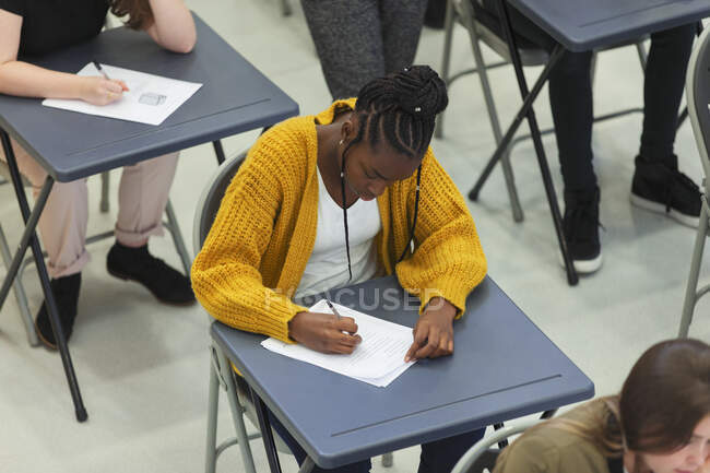 Estudante do ensino médio focado fazendo exame na mesa em sala de aula — Fotografia de Stock
