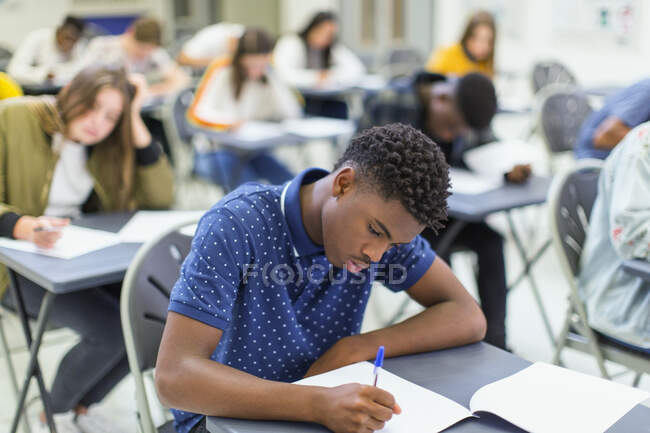 Étudiant ciblé du secondaire passant un examen au bureau en classe — Photo de stock