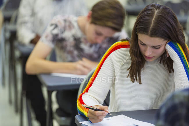 Étudiante ciblée du secondaire passant un examen au bureau en classe — Photo de stock