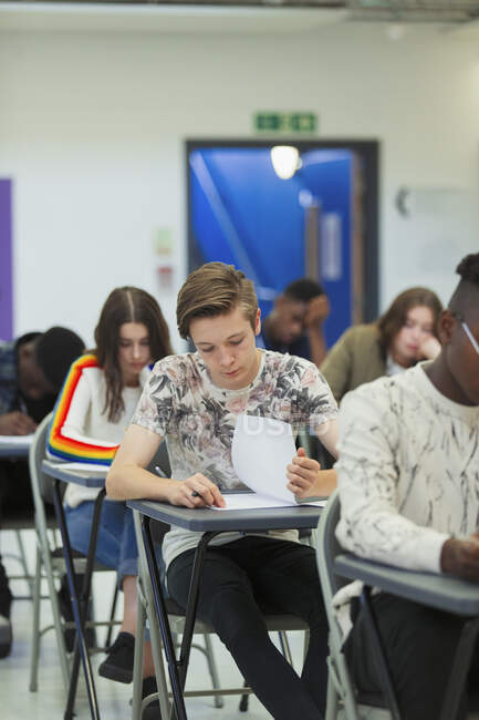 Зосереджений на старшокласнику здавав екзамен за столом у класі. — Stock Photo