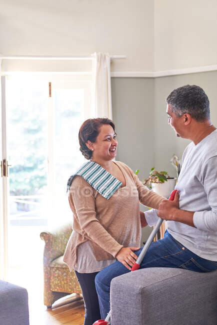 Couple d'âge mûr parler et nettoyage maison — Photo de stock