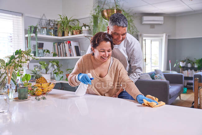 Glücklich liebevoll reifes Paar putzt Kücheninsel — Stockfoto