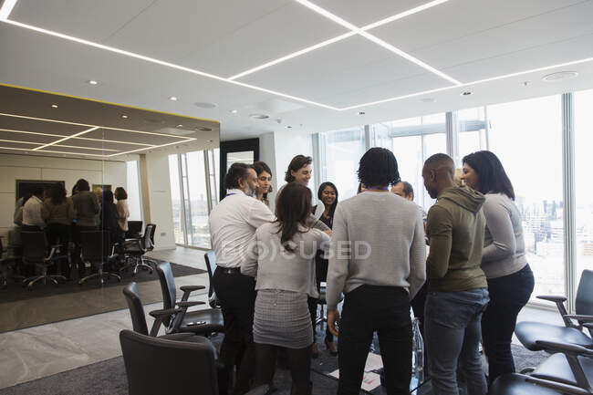 Business people standing in huddle in office — Stock Photo