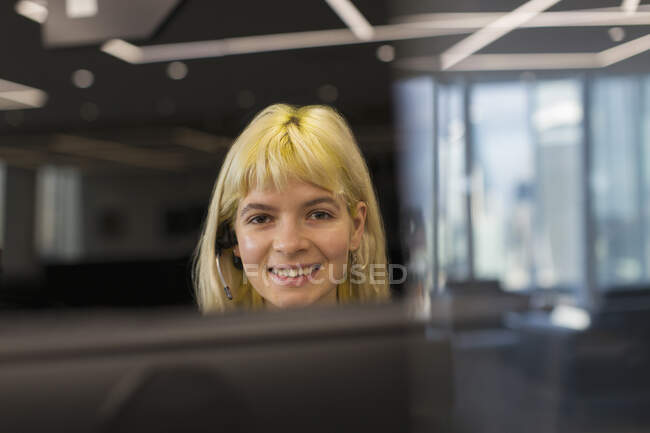 Retrato confiante empresária vestindo fone de ouvido no escritório — Fotografia de Stock