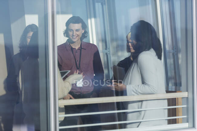 Uomini d'affari che parlano in una finestra soleggiata — Foto stock