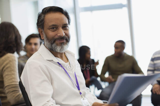 Retrato empresário confiante com papelada em reunião de escritório — Fotografia de Stock