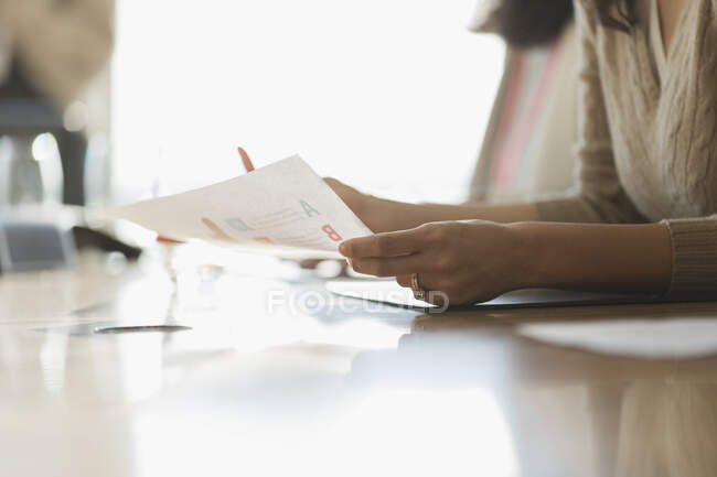 Empresaria con papeleo en reunión de sala de conferencias - foto de stock