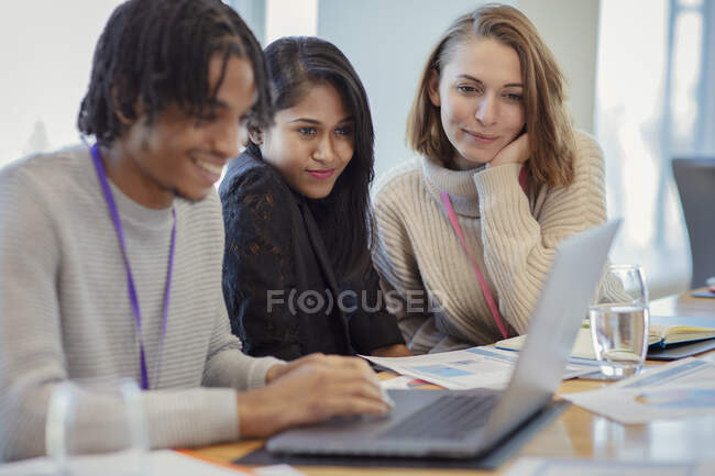 Business people using laptop in meeting — Stock Photo