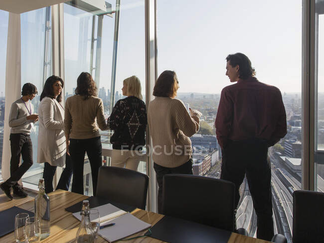 Business people talking at urban conference room window — Stock Photo