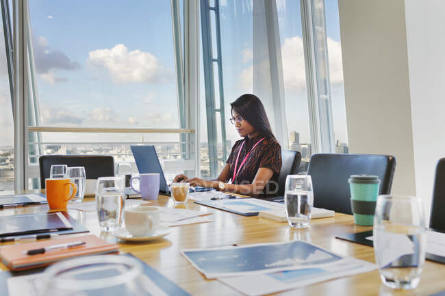 Konzentrierte Geschäftsfrau arbeitet im Konferenzraum am Laptop — Stockfoto
