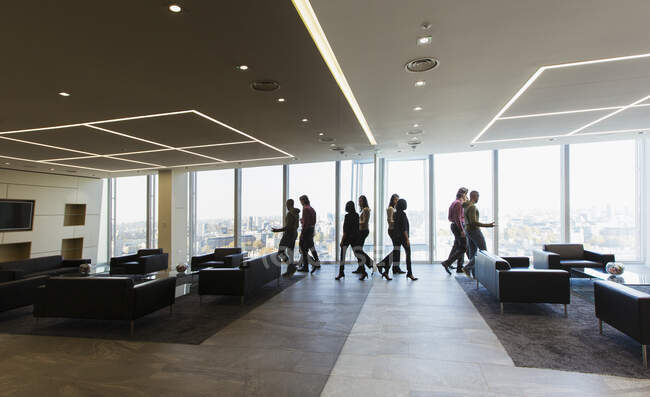 Uomini d'affari che camminano nella moderna hall dell'ufficio — Foto stock