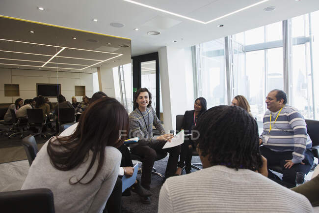 Empresários discutindo papelada em círculo em reunião — Fotografia de Stock