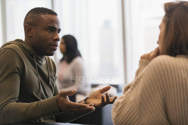 Businessman explaining to colleague in office — Stock Photo