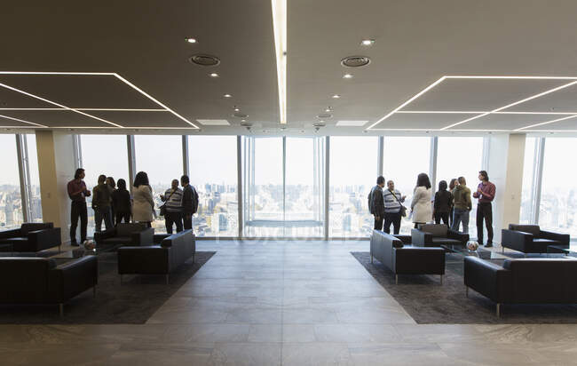 Gente de negocios hablando en el moderno vestíbulo de oficinas - foto de stock