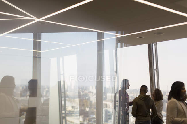 Gente de negocios hablando en oficina de rascacielos - foto de stock