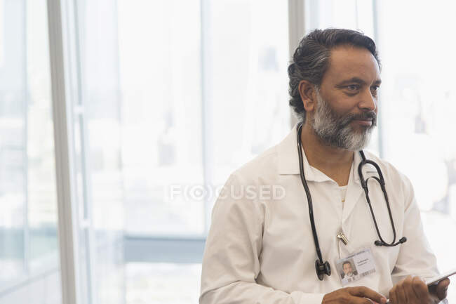 Male doctor with stethoscope in office — Stock Photo