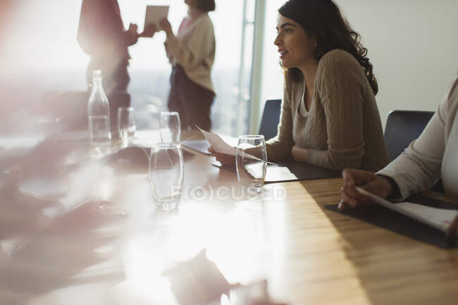 Negócios falando na sala de reuniões ensolarada — Fotografia de Stock
