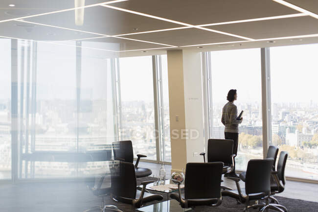 Thoughtful businessman at sunny highrise office window — Stock Photo