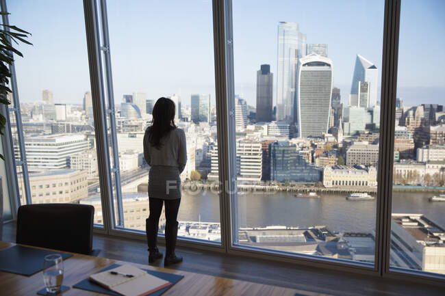 Nachdenkliche Geschäftsfrau betrachtet Stadtansichten, London, Großbritannien — Stockfoto