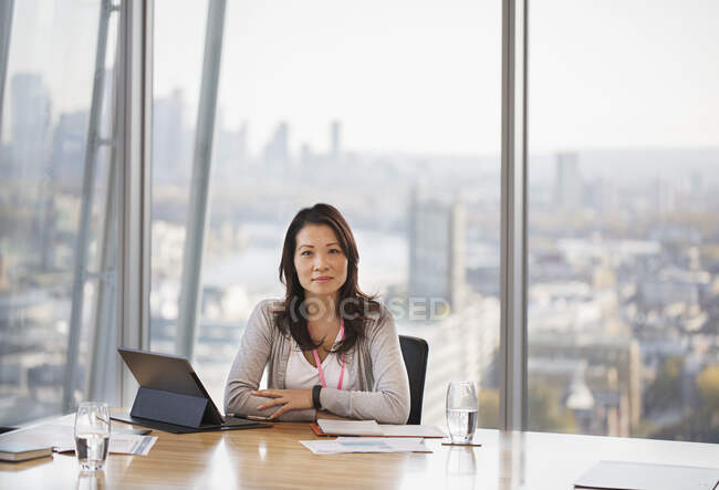 Retrato mujer de negocios confiada trabajando en sala de conferencias urbana - foto de stock