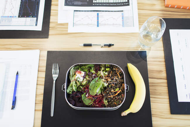 Healthy salad and banana lunch on conference table — Stock Photo