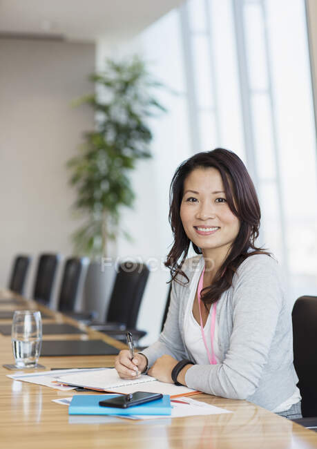 Портрет впевнена бізнес-леді, що працює за конференц-столом — стокове фото