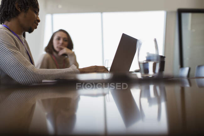 Gente de negocios planeando en la computadora portátil en reunión de sala de conferencias - foto de stock